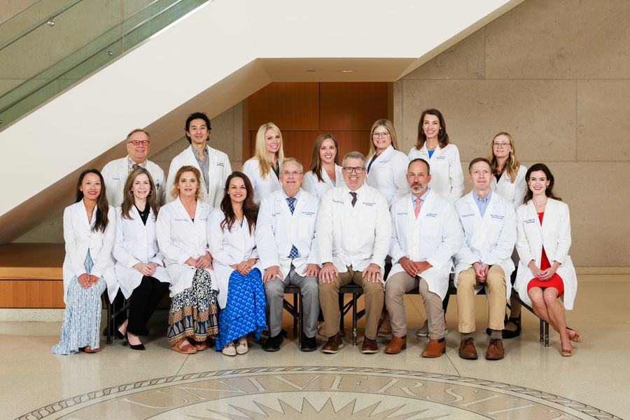 Faculty of the Department of Dermatology pose for a group photo in the School of Medicine's lobby.